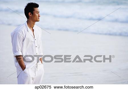 Man standing on beach, hands in pocket, looking away View Large Photo Image Stock Photography - Man standing on beach, hands in pocket, looking away . Fotosearch