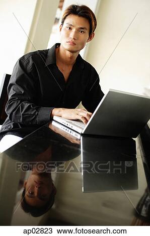 Man using laptop, looking at camera View Large Photo Image Stock Image - Man using laptop, looking at camera . Fotosearch