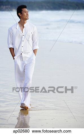Man walking on beach, hands in pocket View Large Photo Image Stock Image - Man walking on beach, hands in pocket. Fotosearch