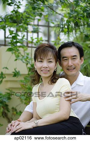 Mature couple sitting on bench, woman leaning against man View Large Photo Image Stock Photograph - Mature couple sitting on bench, woman leaning against man . Fotosearch