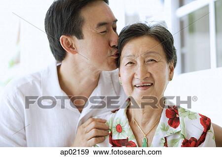 Mother and adult son together, son giving mother a kiss View Large Photo Image Stock Photo - Mother and adult son together, son giving mother a kiss . Fotosearch