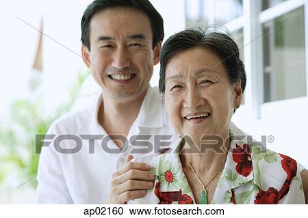 Mother and son looking at camera smiling View Large Photo Image Stock Image - Mother and son looking at camera smiling . Fotosearch