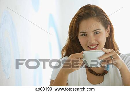 One woman holding cup, looking at camera View Large Photo Image Stock Photo - One woman holding cup, looking at camera. Fotosearch