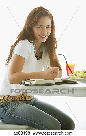 One woman sitting at table, smiling at camera View Large Photo Image Stock Photo - One woman sitting at table, smiling at camera . Fotosearch
