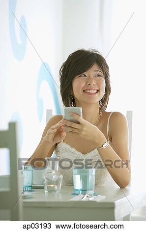 One woman sitting in cafe, holding compact, smiling View Large Photo Image Stock Image - One woman sitting in cafe, holding compact, smiling . Fotosearch