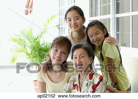 Stock Image - Three generation family, looking at camera, smiling . Fotosearch