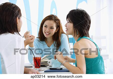 Three young women in cafe, talking View Large Photo Image Picture - Three young women in cafe, talking . Fotosearch