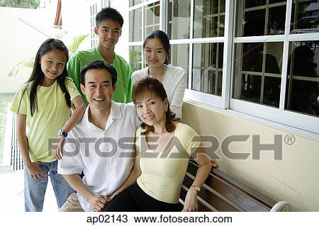 Stock Image - Two generation family looking at camera and smiling . Fotosearch