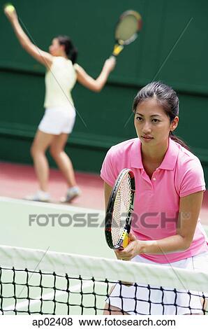 Stock Photo - Two women playing tennis, mixed doubles . Fotosearch