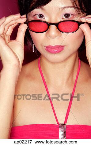 Woman adjusting sunglasses, looking at camera View Large Photo Image Stock Photo - Woman adjusting sunglasses, looking at camera. Fotosearch