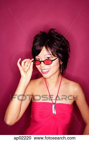Woman adjusting sunglasses, smiling at camera View Large Photo Image Stock Image - Woman adjusting sunglasses, smiling at camera . Fotosearch