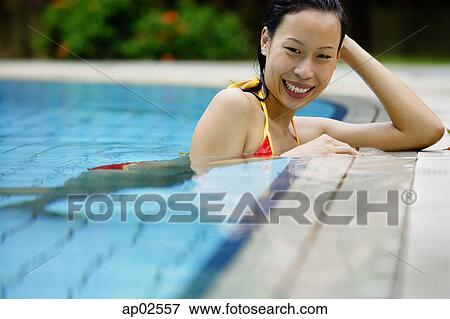 Woman at the edge of swimming pool, smiling at camera View Large Photo Image Stock Photo - Woman at the edge of swimming pool, smiling at camera . Fotosearch