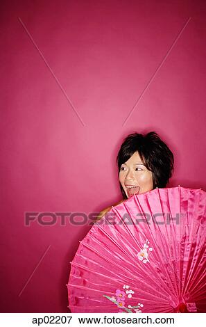 Woman behind pink umbrella, against pink background View Large Photo Image Stock Photo - Woman behind pink umbrella, against pink background. Fotosearch