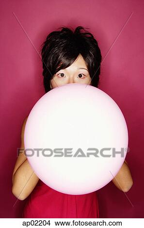 Picture - Woman blowing pink balloon . Fotosearch