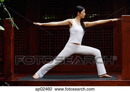 Stock Image - Woman doing a yoga pose with arms outstretched . Fotosearch