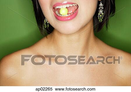 Woman eating green sweet, cropped image View Large Photo Image Stock Photography - Woman eating green sweet, cropped image. Fotosearch