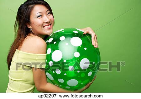Woman embracing inflatable ball, smiling at camera View Large Photo Image Stock Photo - Woman embracing inflatable ball, smiling at camera . Fotosearch