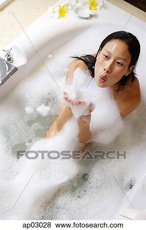 Woman having bubble bath, blowing soap suds View Large Photo Image Stock Photo - Woman having bubble bath, blowing soap suds . Fotosearch