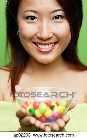 Woman holding a bowl of candy View Large Photo Image Stock Image - Woman holding a bowl of candy . Fotosearch