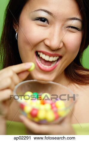 Woman holding candy and candy bowl, winking View Large Photo Image Stock Image - Woman holding candy and candy bowl, winking . Fotosearch