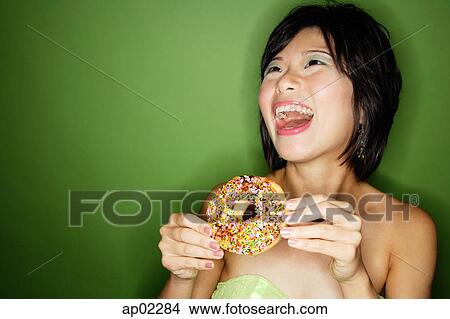 Woman holding donut, laughing View Large Photo Image Picture - Woman holding donut, laughing. Fotosearch