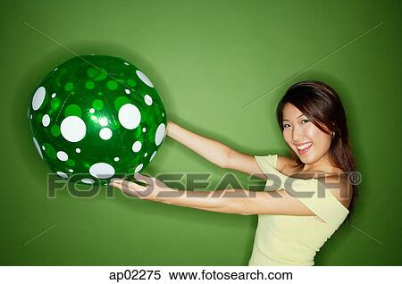 Woman holding inflatable ball, arms outstretched View Large Photo Image Stock Photography - Woman holding inflatable ball, arms outstretched . Fotosearch