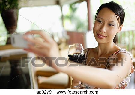 Woman holding mobile phone, taking photograph View Large Photo Image Stock Image - Woman holding mobile phone, taking photograph . Fotosearch