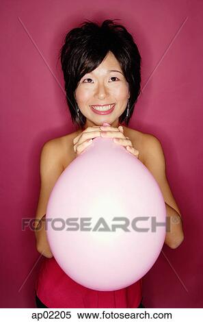 Stock Photography - Woman holding pink balloon . Fotosearch