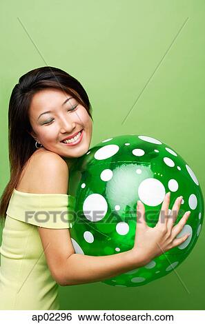 Woman hugging inflatable ball, eyes closed View Large Photo Image Stock Photograph - Woman hugging inflatable ball, eyes closed . Fotosearch