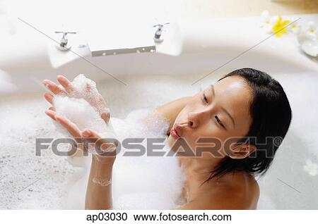 Woman in bathtub, blowing soap suds View Large Photo Image Stock Image - Woman in bathtub, blowing soap suds. Fotosearch