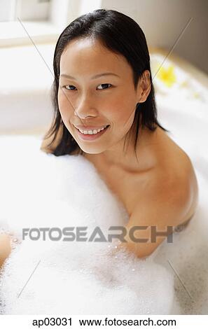 Woman in bathtub, covered with soap suds, smiling at camera View Large Photo Image Stock Image - Woman in bathtub, covered with soap suds, smiling at camera . Fotosearch