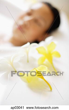 Woman in bathtub, focus on the flowers at the edge of tub View Large Photo Image Stock Image - Woman in bathtub, focus on the flowers at the edge of tub . Fotosearch
