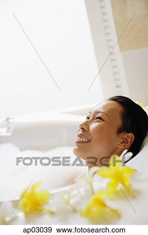 Woman in bathtub, smiling, looking away View Large Photo Image Stock Photo - Woman in bathtub, smiling, looking away . Fotosearch