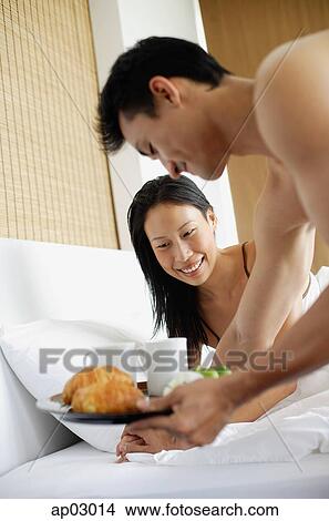 Woman in bed, man bringing breakfast tray View Large Photo Image Picture - Woman in bed, man bringing breakfast tray. Fotosearch