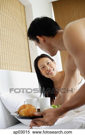 Woman in bed, man holding breakfast tray View Large Photo Image Stock Photography - Woman in bed, man holding breakfast tray. Fotosearch