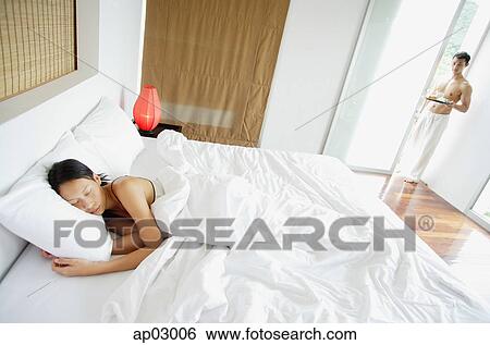 Woman in bedroom, sleeping, man standing at doorway, holding tray View Large Photo Image Stock Photograph - Woman in bedroom, sleeping, man standing at doorway, holding tray . Fotosearch