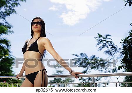 Woman in bikini and sunglasses, leaning on railing View Large Photo Image Stock Photograph - Woman in bikini and sunglasses, leaning on railing . Fotosearch
