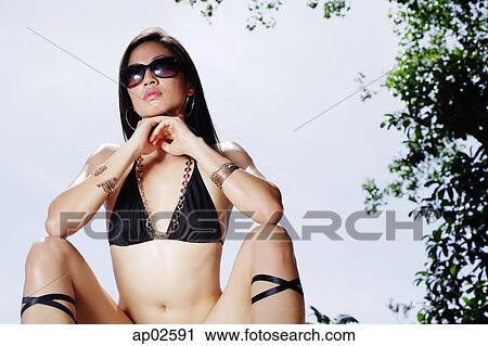Woman in bikini, resting head on hands, facing camera View Large Photo Image Stock Image - Woman in bikini, resting head on hands, facing camera . Fotosearch