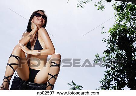 Woman in bikini, sitting, legs apart, hand on neck View Large Photo Image Stock Photo - Woman in bikini, sitting, legs apart, hand on neck. Fotosearch