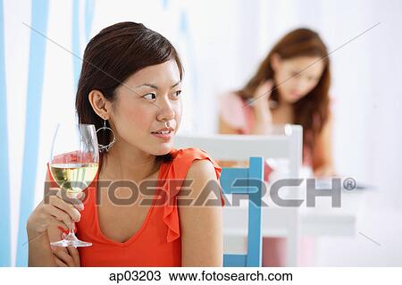 Woman in cafe, holding wine glass, looking away View Large Photo Image Stock Image - Woman in cafe, holding wine glass, looking away. Fotosearch