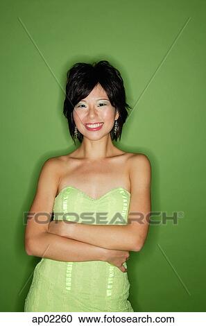 Woman in green dress, arms crossed, smiling at camera View Large Photo Image Stock Image - Woman in green dress, arms crossed, smiling at camera . Fotosearch