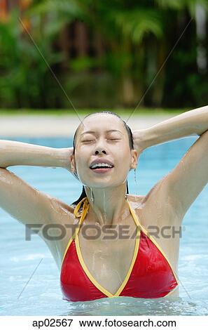 Stock Photo - Woman in red bikini in swimming pool . Fotosearch