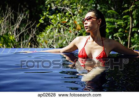 Woman in red bikini, sitting in swimming pool View Large Photo Image Stock Photo - Woman in red bikini, sitting in swimming pool. Fotosearch
