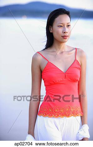 Picture - Woman in red top, standing, looking away . Fotosearch