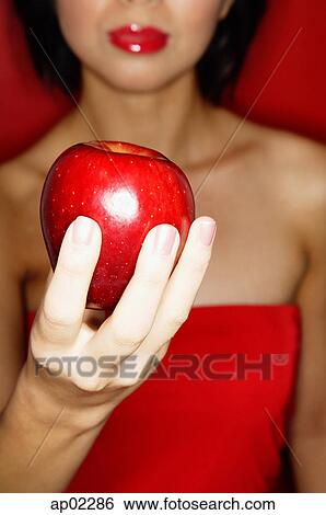 Woman in red tube tope holding red apple View Large Photo Image Stock Photograph - Woman in red tube tope holding red apple . Fotosearch