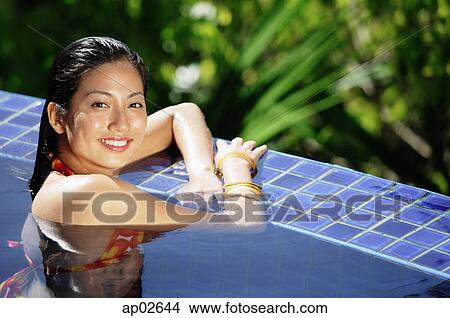 Woman in swimming pool, smiling at camera View Large Photo Image Picture - Woman in swimming pool, smiling at camera . Fotosearch