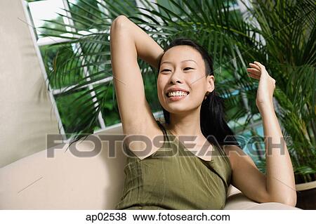 Woman on arm chair, hand behind head View Large Photo Image Stock Photo - Woman on arm chair, hand behind head. Fotosearch