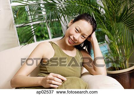 Woman on arm chair, smiling at camera, portrait View Large Photo Image Stock Photo - Woman on arm chair, smiling at camera, portrait. Fotosearch