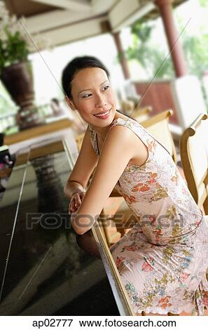 Stock Photo - Woman sitting at bar, leaning on counter, looking over shoulder . Fotosearch