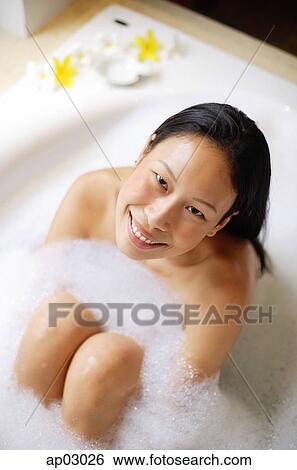 Woman sitting in bathtub, smiling up at camera View Large Photo Image Stock Photograph - Woman sitting in bathtub, smiling up at camera . Fotosearch